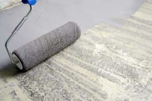 Penetrační nátěr nanášený válečkem na betonový podklad před nivelací nebo lepením podlahy