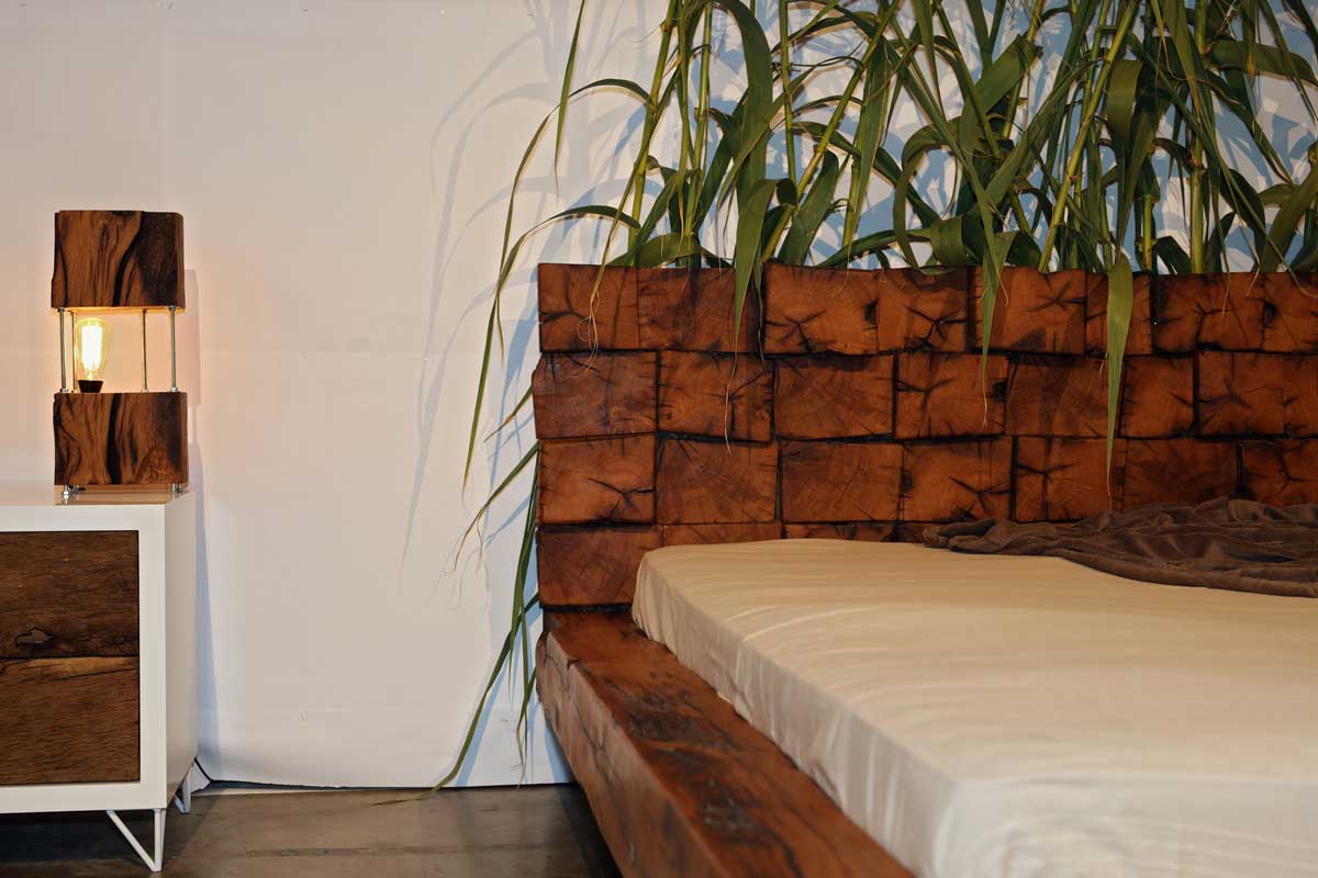 Postel z masivního dřeva s výraznou kresbou letokruhů a robustním čelem.