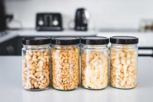 Upcyklace sklenic od potravin využitých jako praktické dózy na ořechy a suroviny v kuchyni.