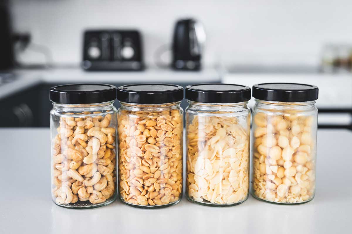 Upcyklace sklenic od potravin využitých jako praktické dózy na ořechy a suroviny v kuchyni.