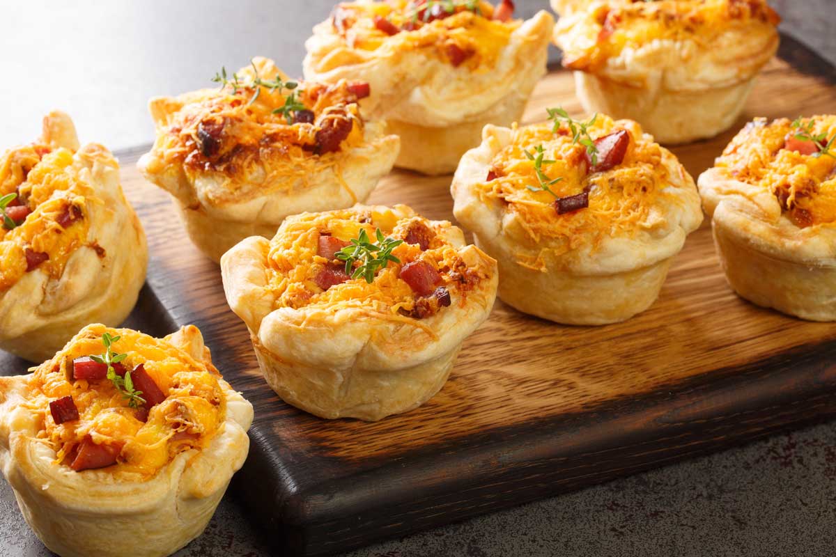 Slané muffiny se sýrem a šunkou upečené dozlatova, vhodné jako teplé pohoštění pro návštěvu