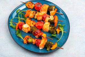 Mini špízy z trouby s klobásou, sýrem, cherry rajčaty a paprikou podávané jako teplá chuťovka