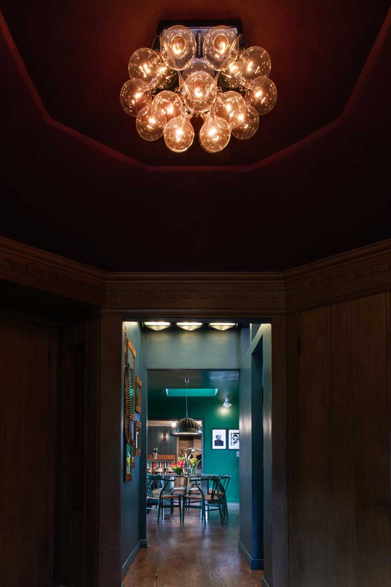 Detail výrazného svítidla ukazuje, jak světlo dotváří atmosféru a podtrhuje barevné vrstvy prostoru.