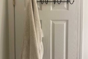 Kovový věšák zavěšený přes horní hranu dveří vytváří úložný prostor bez trvalých zásahů.