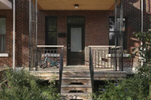 Původní cihlový městský dům z roku 1924 ve čtvrti Villeray s nově upraveným vstupem a krytou verandou.