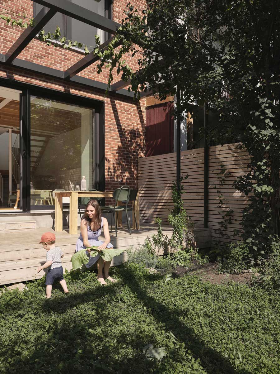 Rodina tráví čas na malé zahradě orientované na jihozápad se vzrostlým šeříkem.