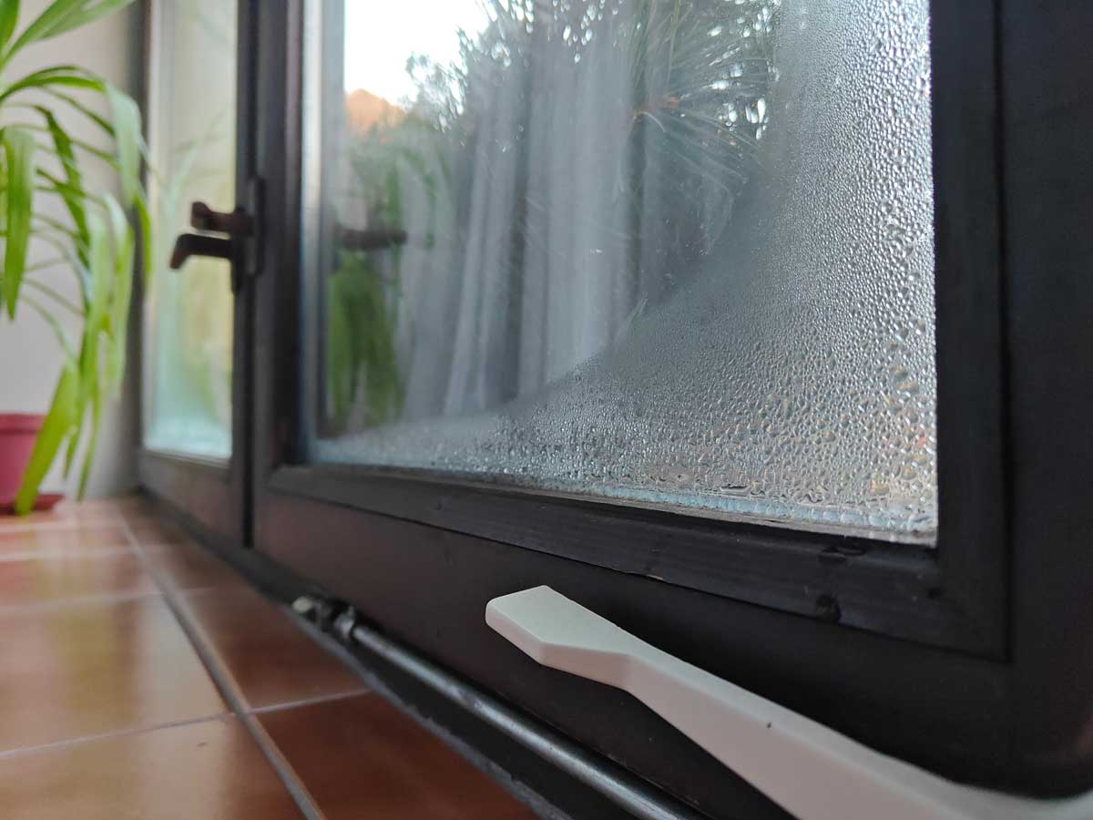 Kondenzace vody na skle zimní zahrady způsobená rozdílem teplot mezi interiérem a mrazivým venkovním vzduchem.