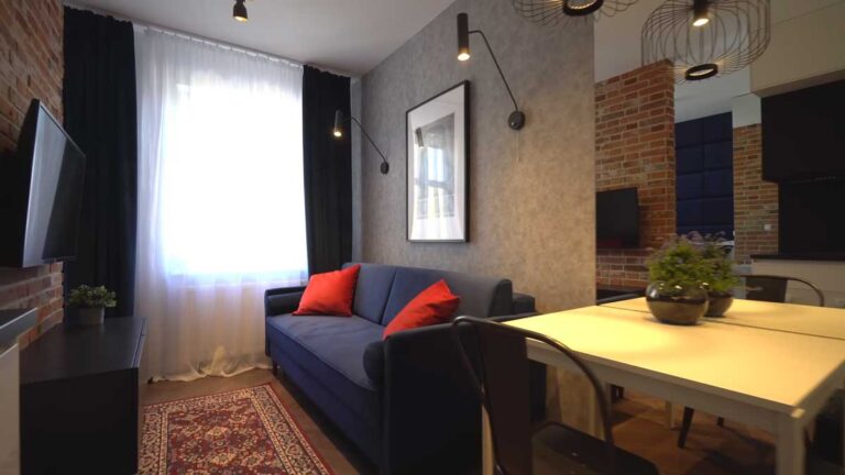 Jídelní kout v malé garsonce se zrcadlem, které opticky zvětšuje prostor a odráží denní světlo