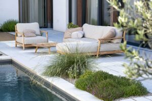 Moderní zahrada s venkovním posezením u vody jako místo pro celoroční relaxaci a odpočinek