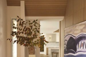 Chodba s dřevěnými prvky a výrazným obrazem propojuje jednotlivé části domu