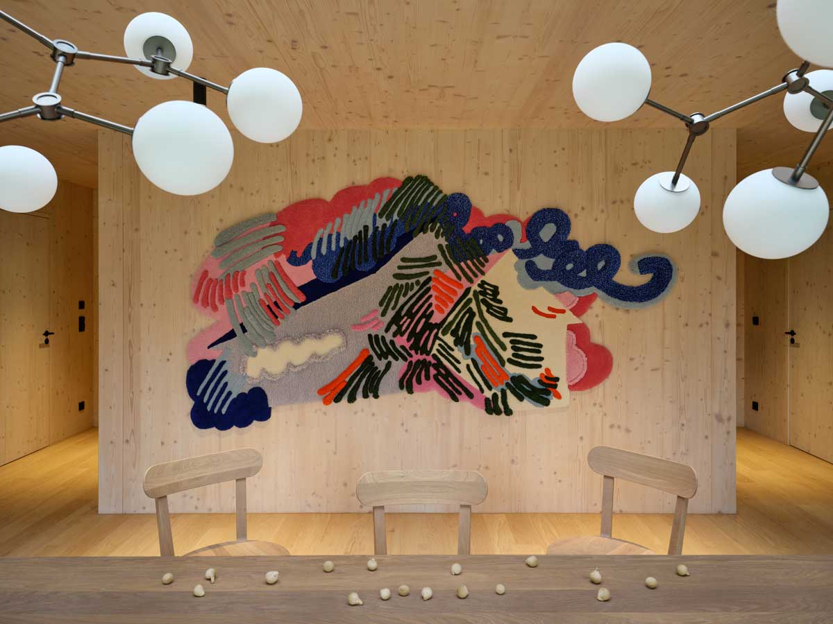 Pohled na chalupu s velkoformátovým oknem zasazenou do lesního prostředí