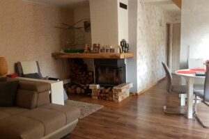 Obývací pokoj s krbem a dřevěnou podlahou v moderním venkovském stylu