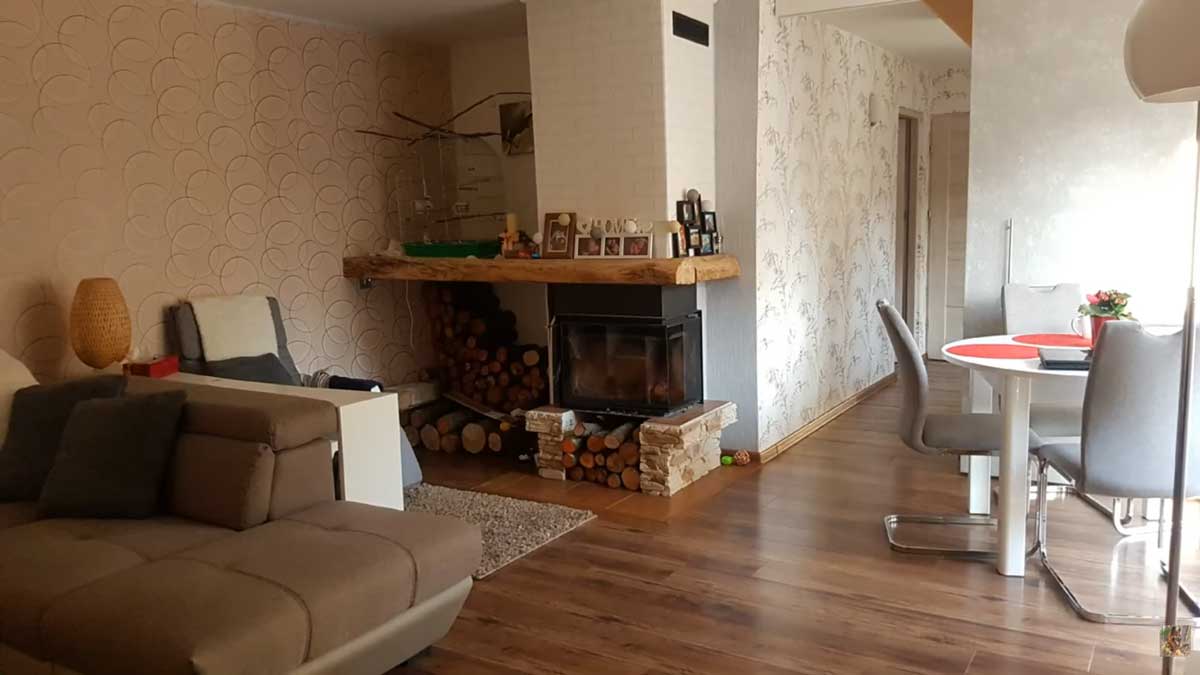 Obývací pokoj s krbem a dřevěnou podlahou v moderním venkovském stylu