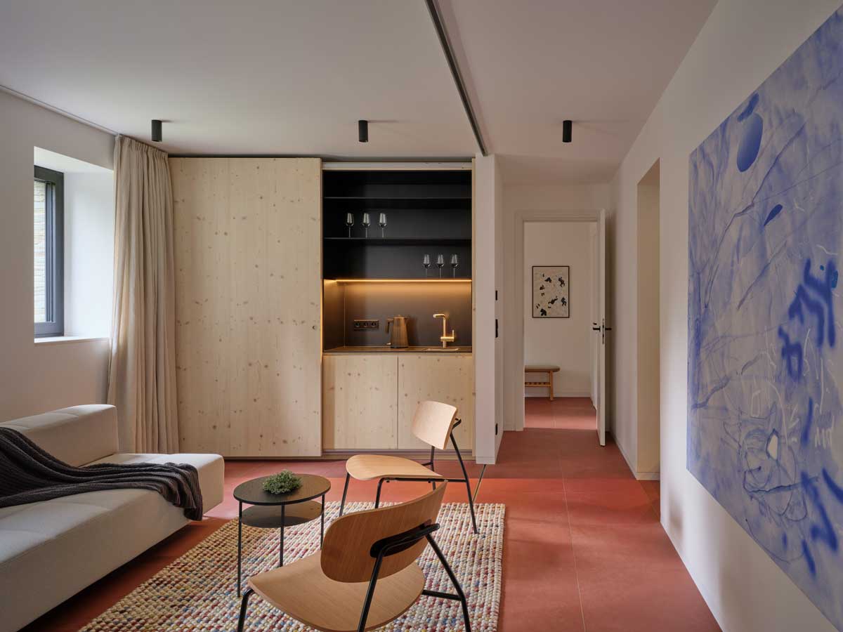 Otevřený obytný prostor s velkým oknem a výhledem do lesa