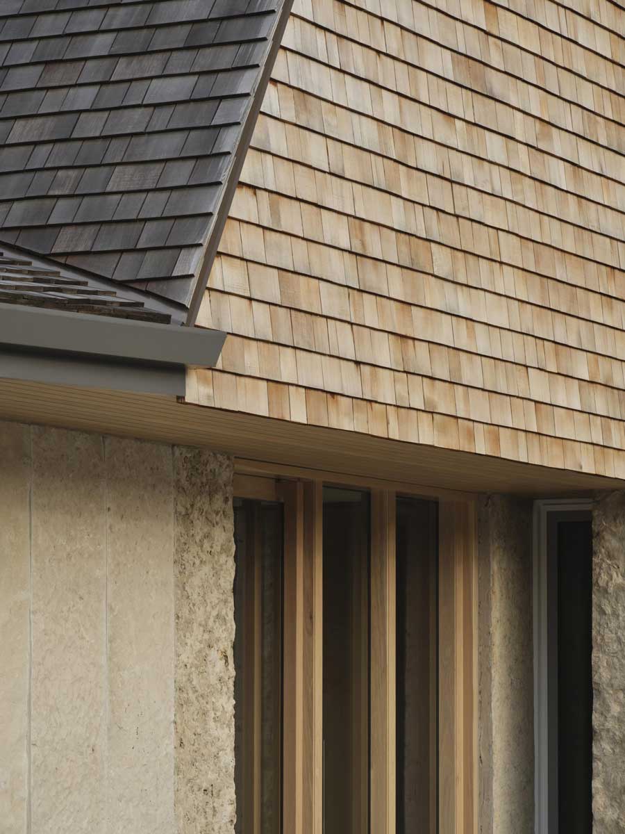 Detail fasády z dřevěných šindelů ukazuje precizní řemeslné zpracování domu