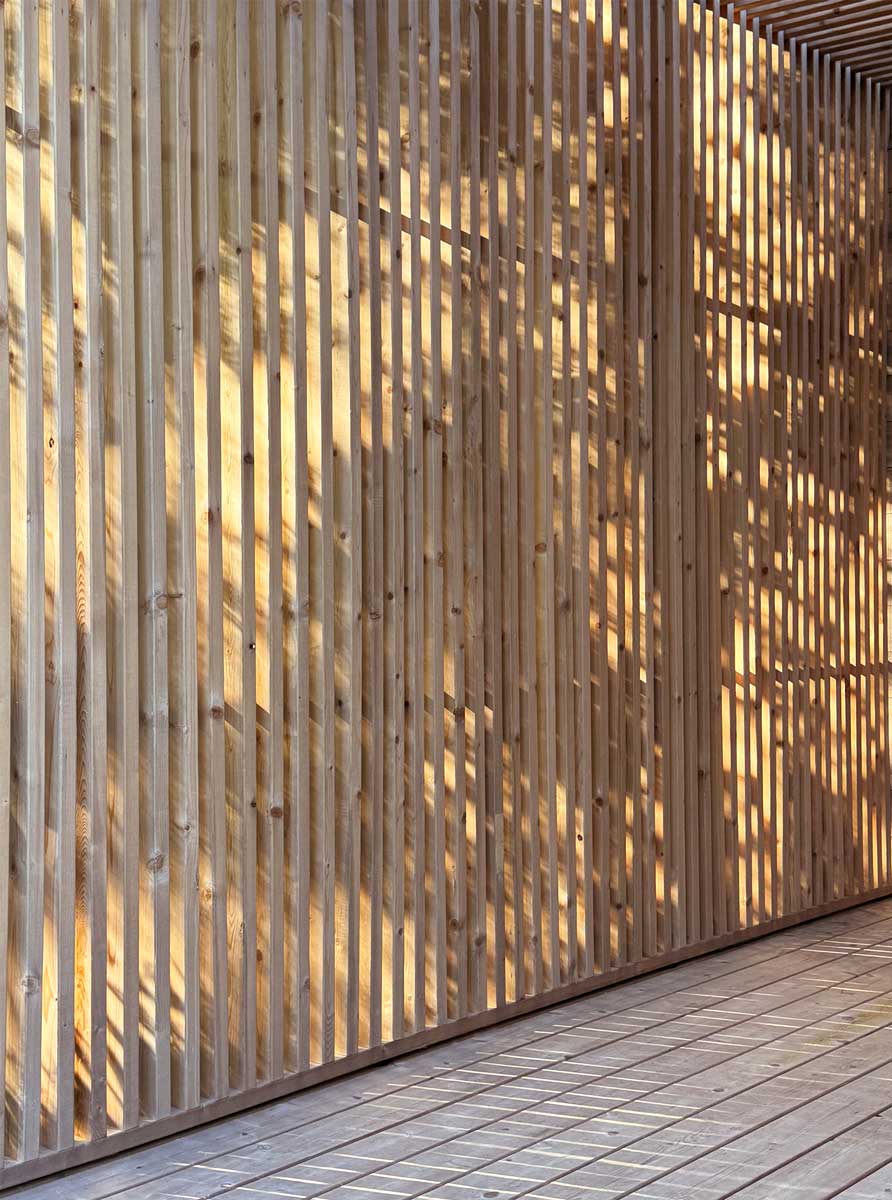 Dřevěné lamelové obložení vytváří zajímavou hru světla a stínu na fasádě domu.