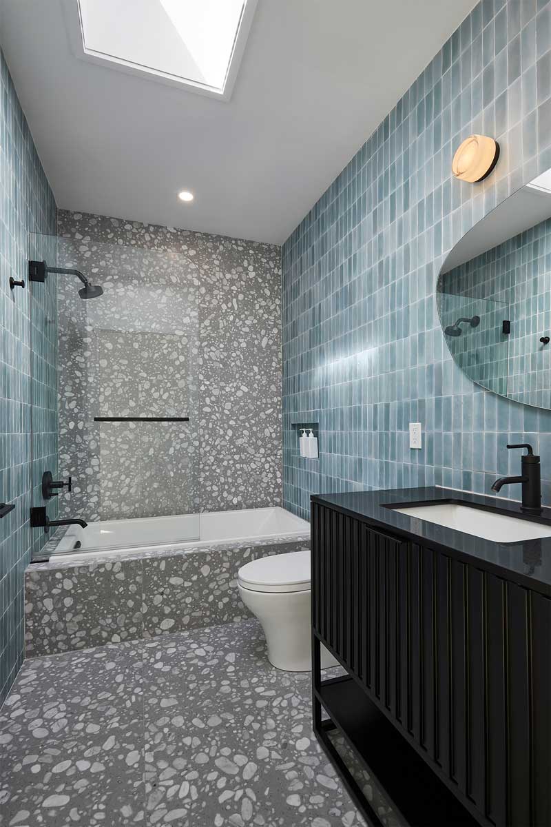 Moderní koupelna s modrými obklady a výraznou strukturou působí svěže a elegantně.