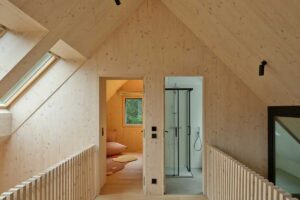 Ochoz v patře s dřevěným zábradlím a dveřmi do jednotlivých místností