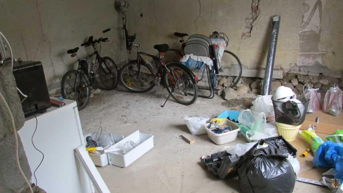 Původní prostor stodoly využívaný jako garáž a sklad před rekonstrukcí