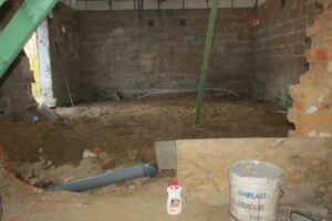 Interiér staré stodoly před rekonstrukcí s původními zdmi a jednoduchou konstrukcí střechy