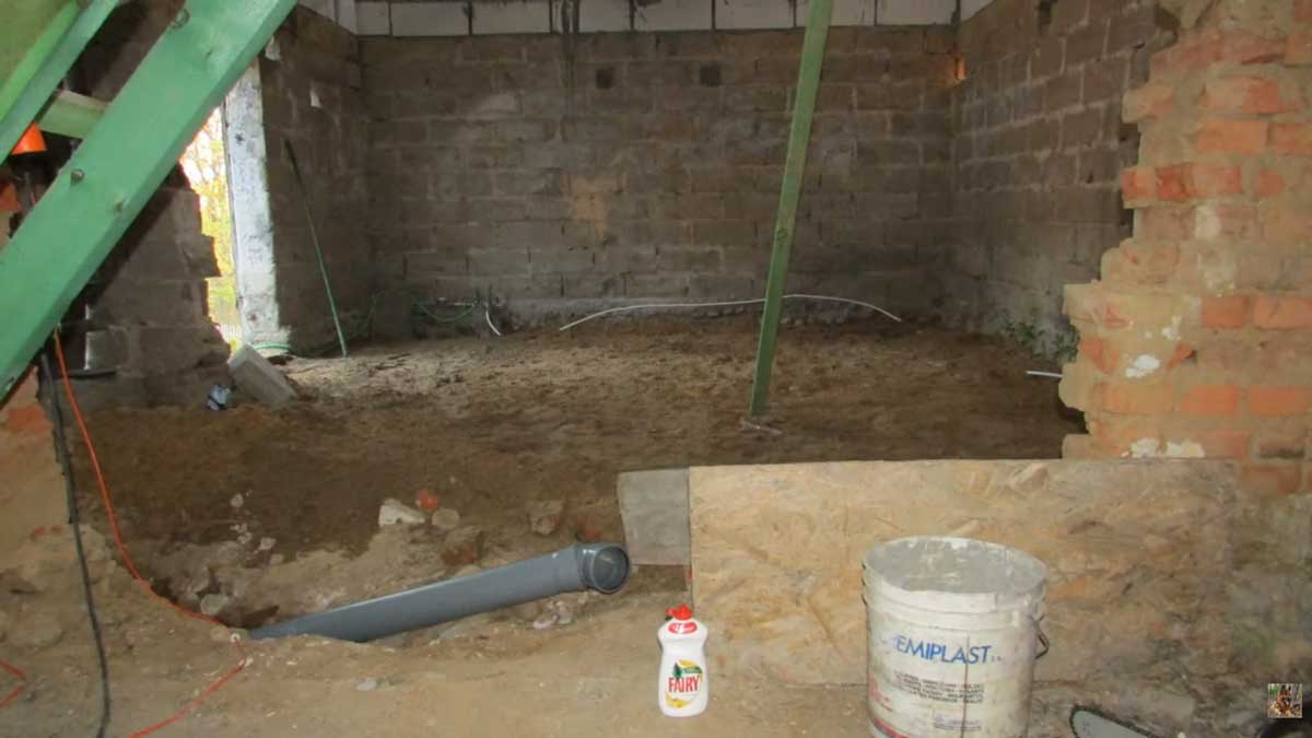 Interiér staré stodoly před rekonstrukcí s původními zdmi a jednoduchou konstrukcí střechy