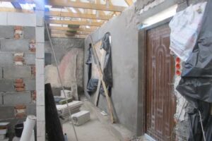 Stavební práce uvnitř domu během rekonstrukce s novými zdmi a střešní konstrukcí