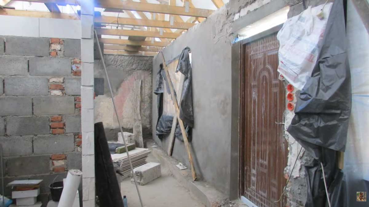 Stavební práce uvnitř domu během rekonstrukce s novými zdmi a střešní konstrukcí