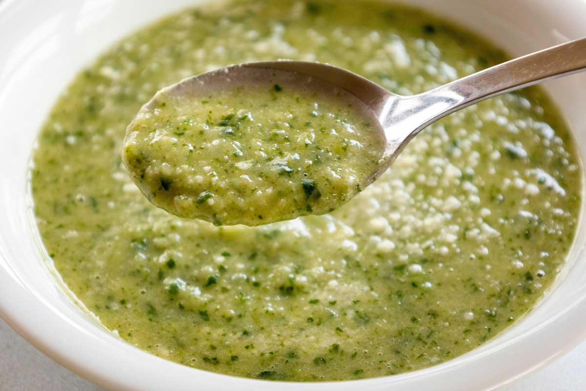 Krémová jarní bylinková polévka z čerstvých zelených rostlin bohatá na vitamíny.