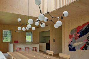 Propojená jídelna s kuchyní v otevřeném dřevěném interiéru