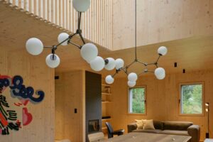 Otevřený obytný prostor s jídelním stolem galerií a dřevěným interiérem