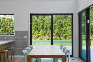 Jídelní kout s jednoduchým dřevěným stolem a výhledem do zahrady podtrhuje klidnou atmosféru domu.Jídelní kout s jednoduchým dřevěným stolem a výhledem do zahrady podtrhuje klidnou atmosféru domu.