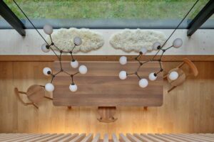 Pohled shora na jídelní stůl pod velkým oknem s výhledem ven