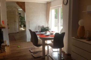 Světlý jídelní kout s kulatým stolem a velkým oknem vedoucím na zahradu