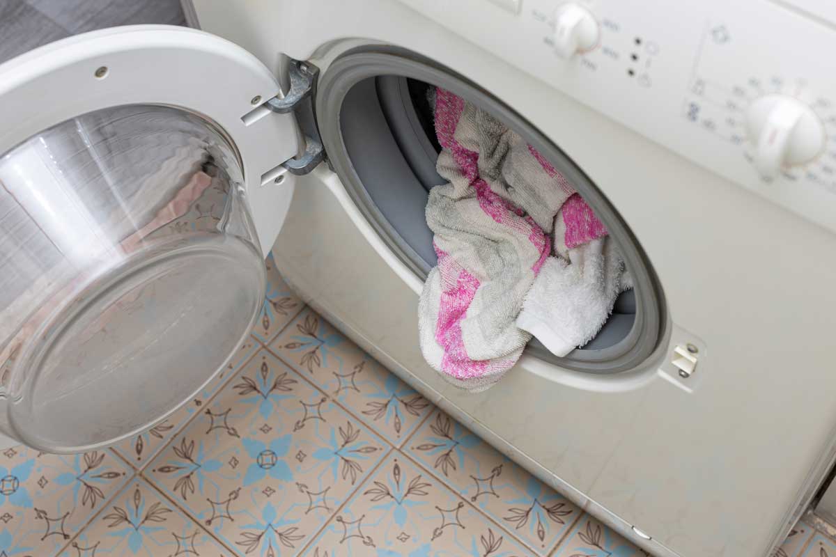 Prostor kolem pračky, kde se hromadí prach, vlákna z prádla a vlhkost při běžném provozu