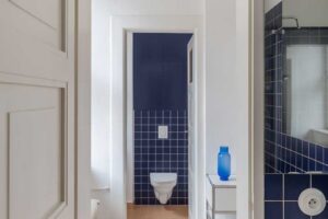 Koupelna s tmavě modrými obklady inspirovanými původními dlaždicemi domu