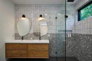 Prostorná koupelna s dvojitým umyvadlem kombinuje přírodní materiály a moderní design.