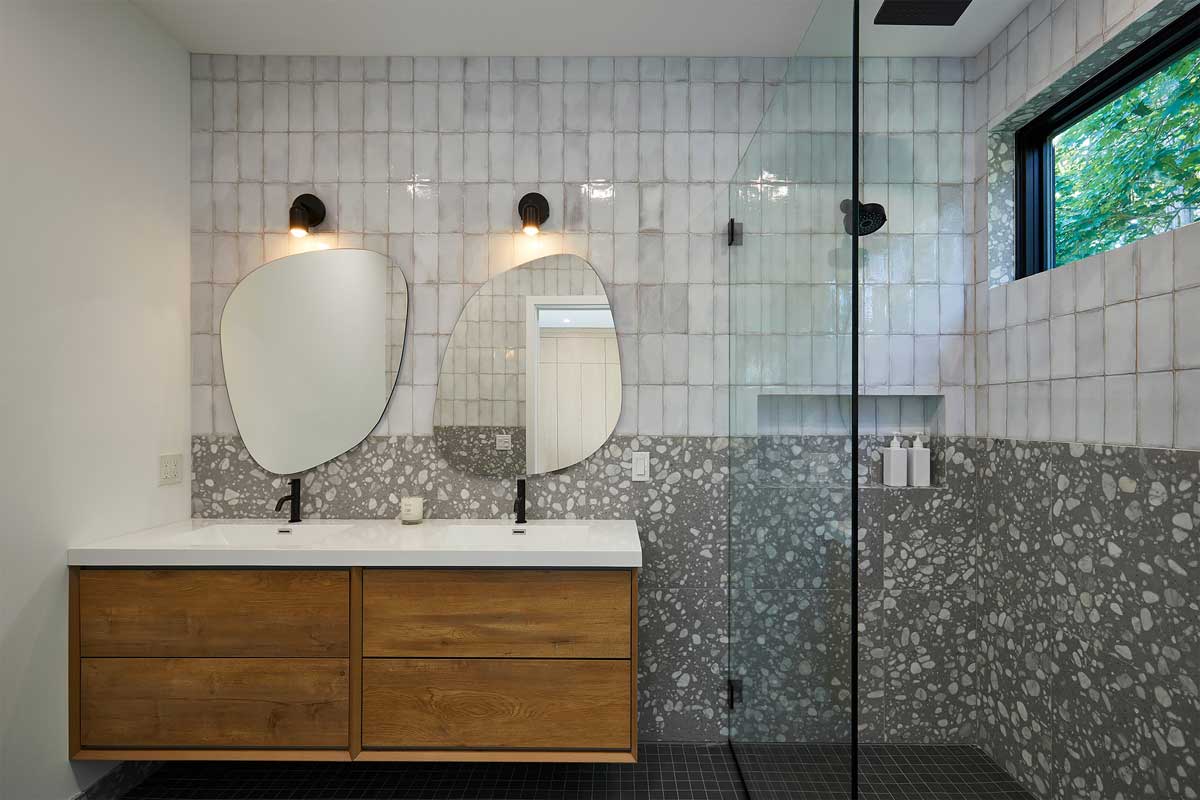 Prostorná koupelna s dvojitým umyvadlem kombinuje přírodní materiály a moderní design.