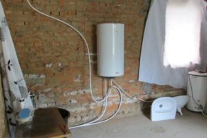 Provizorní koupelna během rekonstrukce s odkrytými cihlovými zdmi