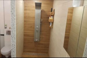 Moderní koupelna se sprchovým koutem a toaletou v neutrálních barvách