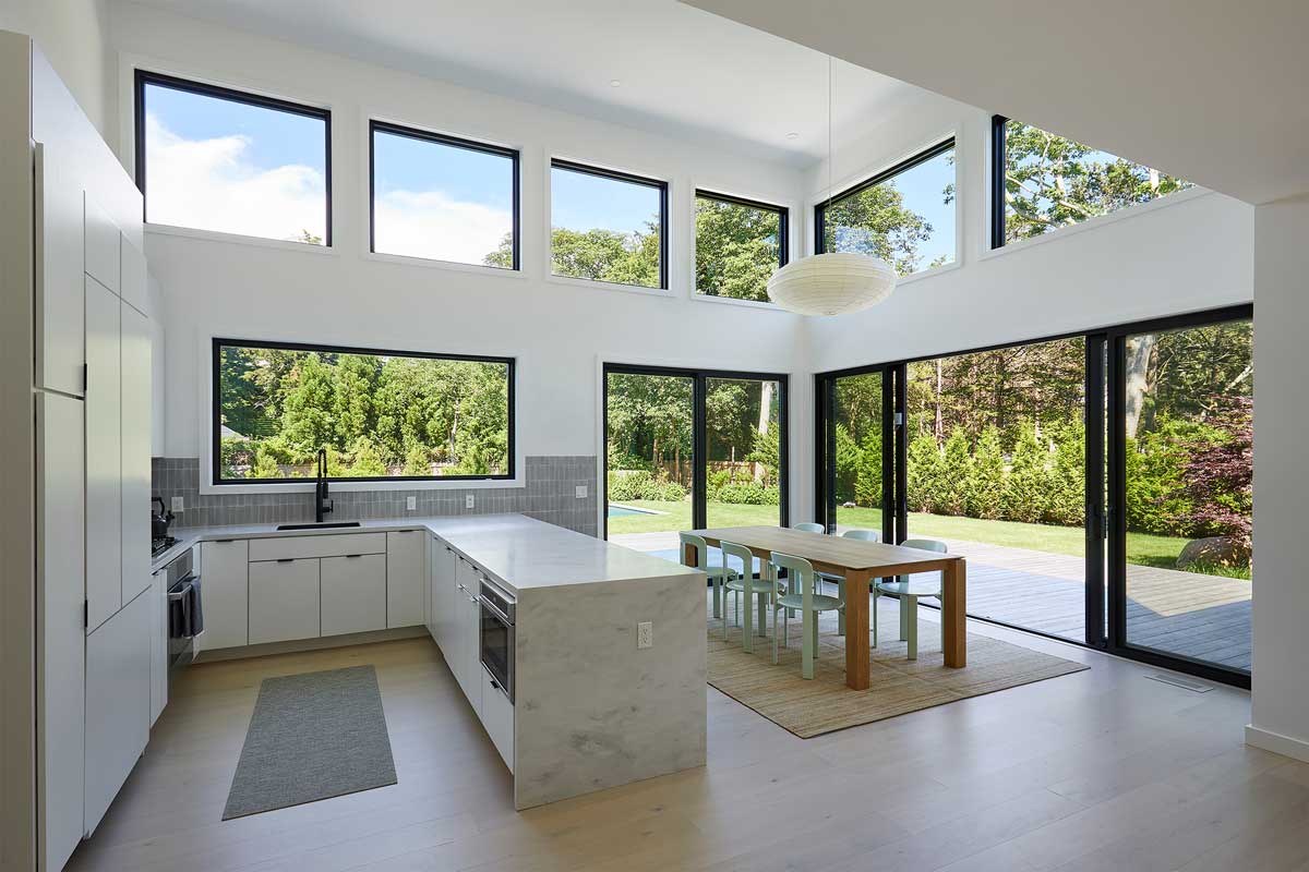 Světlý otevřený interiér propojuje kuchyň s jídelnou a velkými okny otevírá prostor do zahrady.