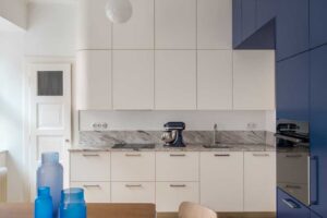 Kuchyň s bílou linkou kamennou deskou a modrým vestavěným nábytkem
