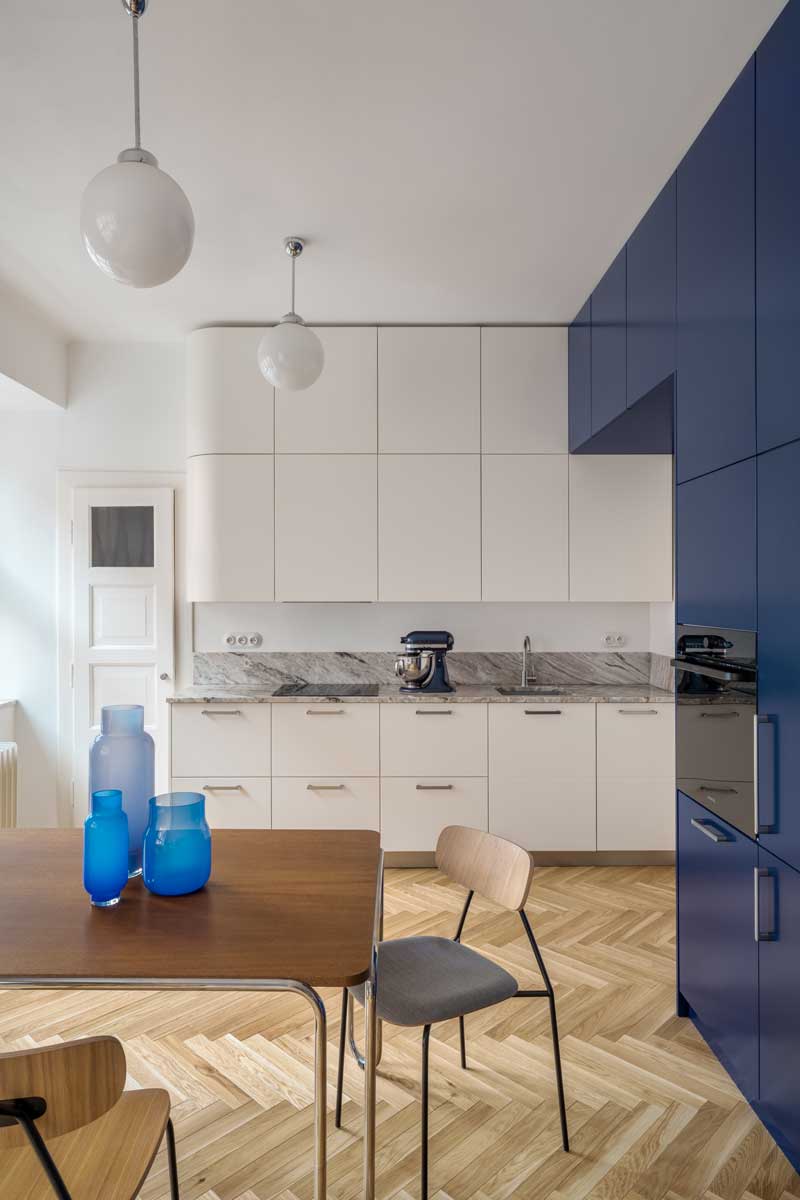 Kuchyň s bílou linkou kamennou deskou a modrým vestavěným nábytkem