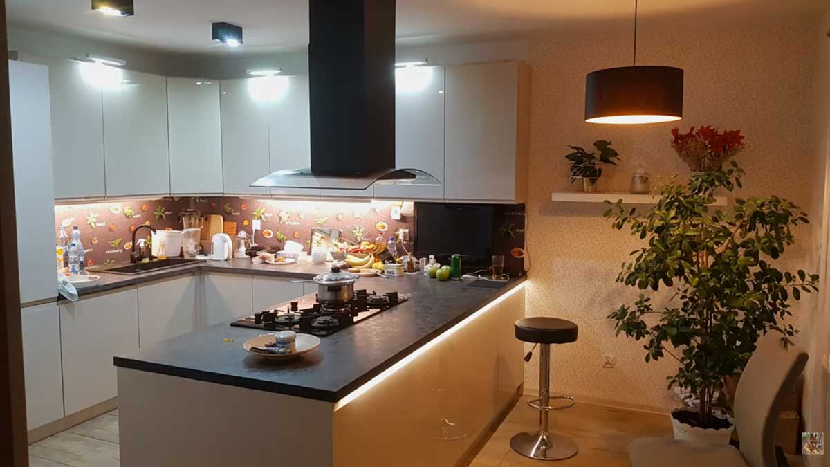 Moderní kuchyně s ostrůvkem a bílými skříňkami v otevřeném obytném prostoru