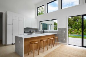 Kuchyňský ostrůvek s dřevěnými detaily a barovým sezením vytváří přirozené centrum domácnosti.