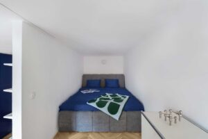 Ložnice v alkovně nad obytným prostorem s čalouněnou postelí