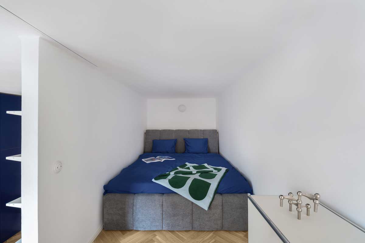 Ložnice v alkovně nad obytným prostorem s čalouněnou postelí