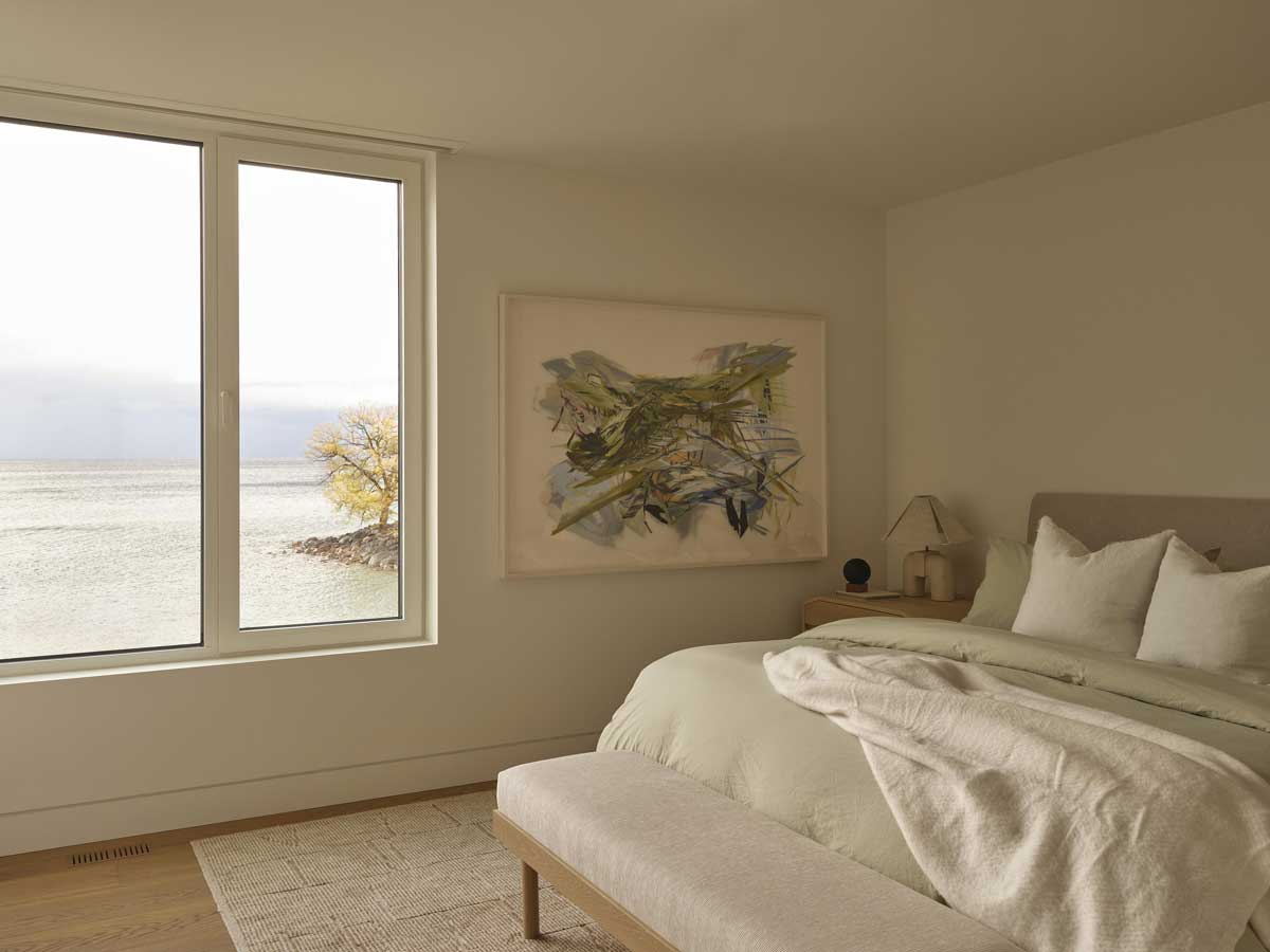 Ložnice s velkým oknem nabízí nerušený výhled na klidnou hladinu jezera