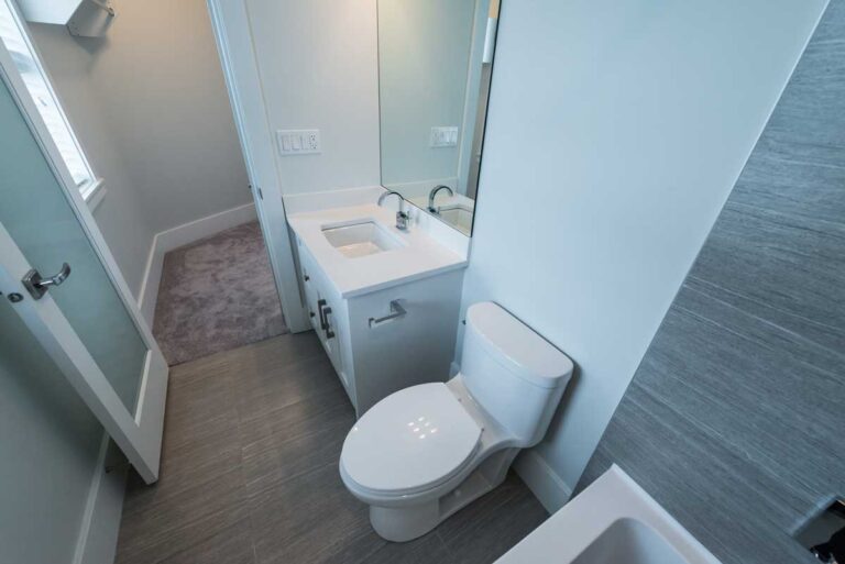 Úzká paneláková koupelna s jednoduchým světlým zařízením