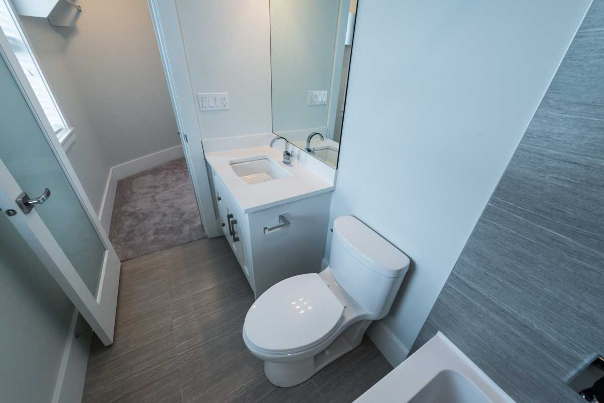 Úzká paneláková koupelna s jednoduchým světlým zařízením