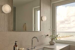 Moderní koupelna s kamennou deskou a velkým zrcadlem působí čistě a nadčasově